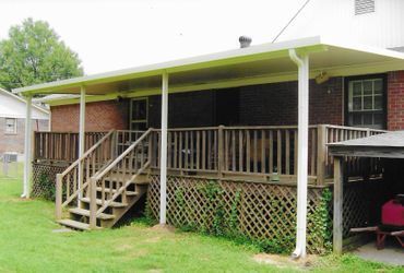 A house with a porch and stairs in the backyard