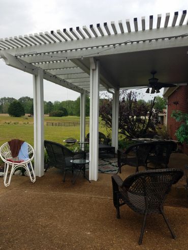 A patio with chairs and a table under a pergola