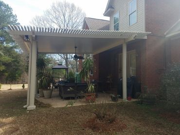 A house with a covered patio and a ceiling fan