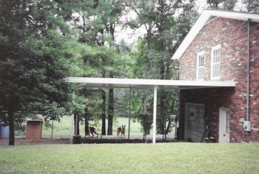 A brick house with a carport in front of it