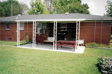 A brick house with a covered porch and a picnic table
