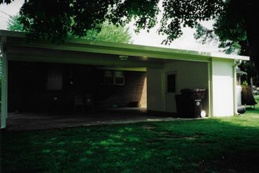 A white garage with a roof that is open