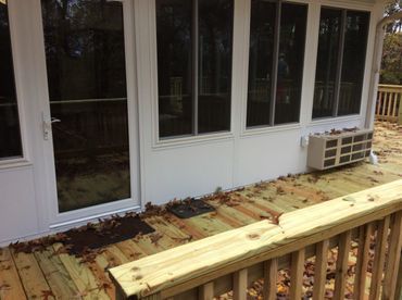 A wooden deck with a white building in the background