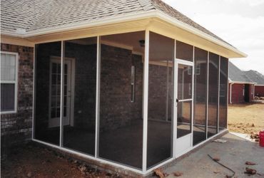 A screened in porch on the side of a house