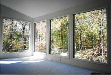 A room with a lot of windows and trees in the background