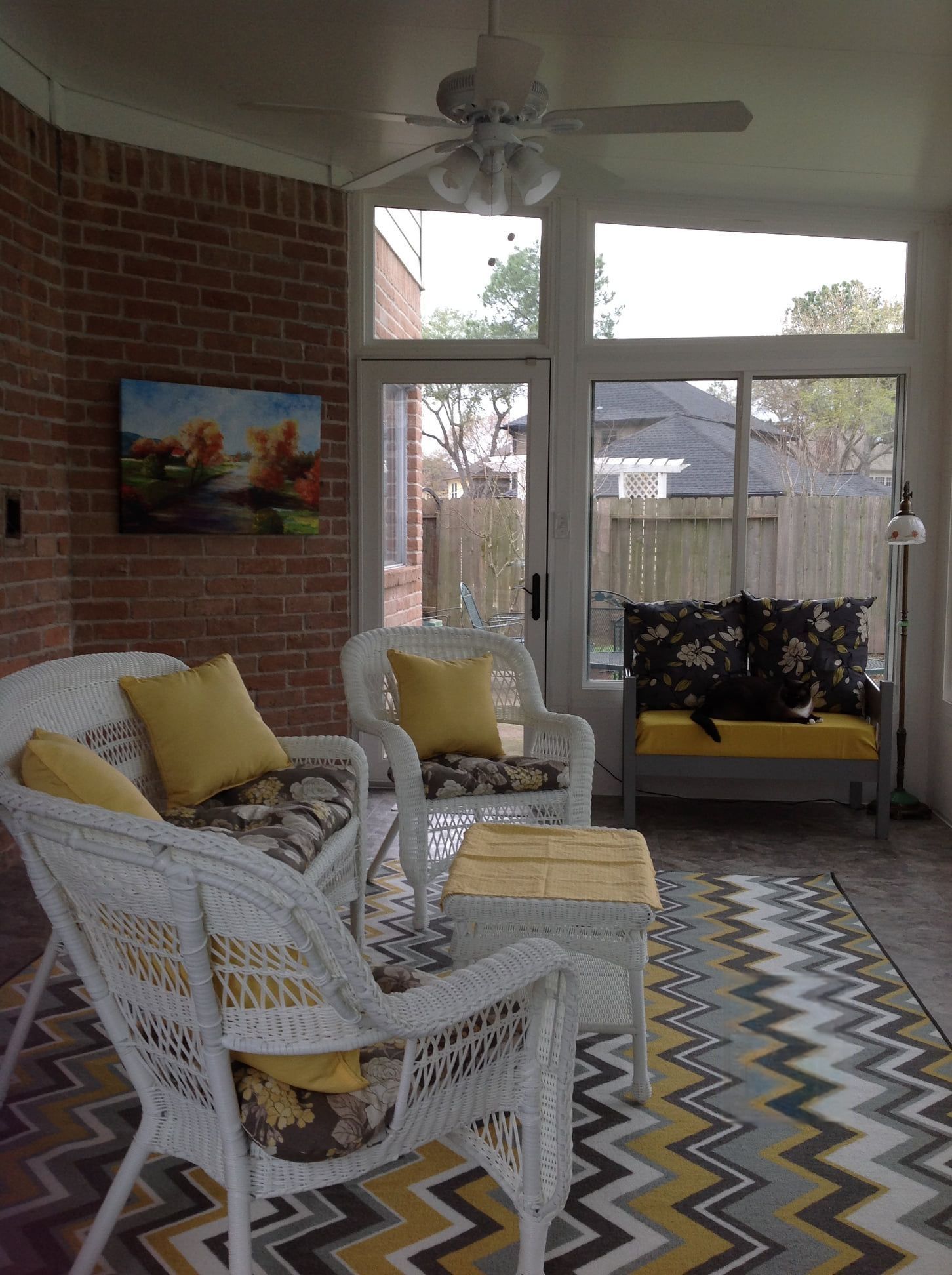 A living room with wicker furniture and a ceiling fan