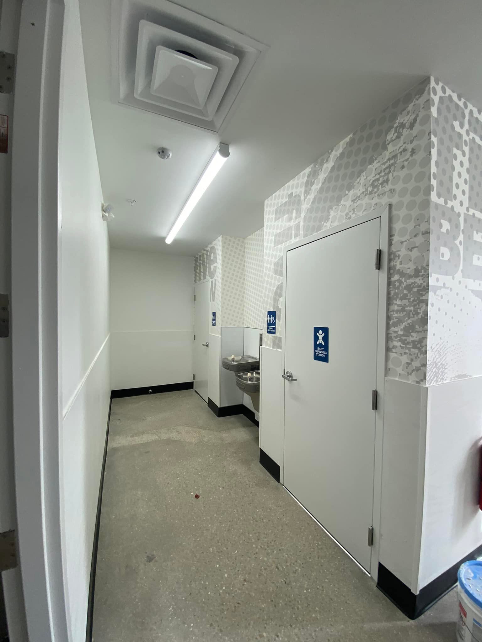 A long hallway with a sink in the middle of it.