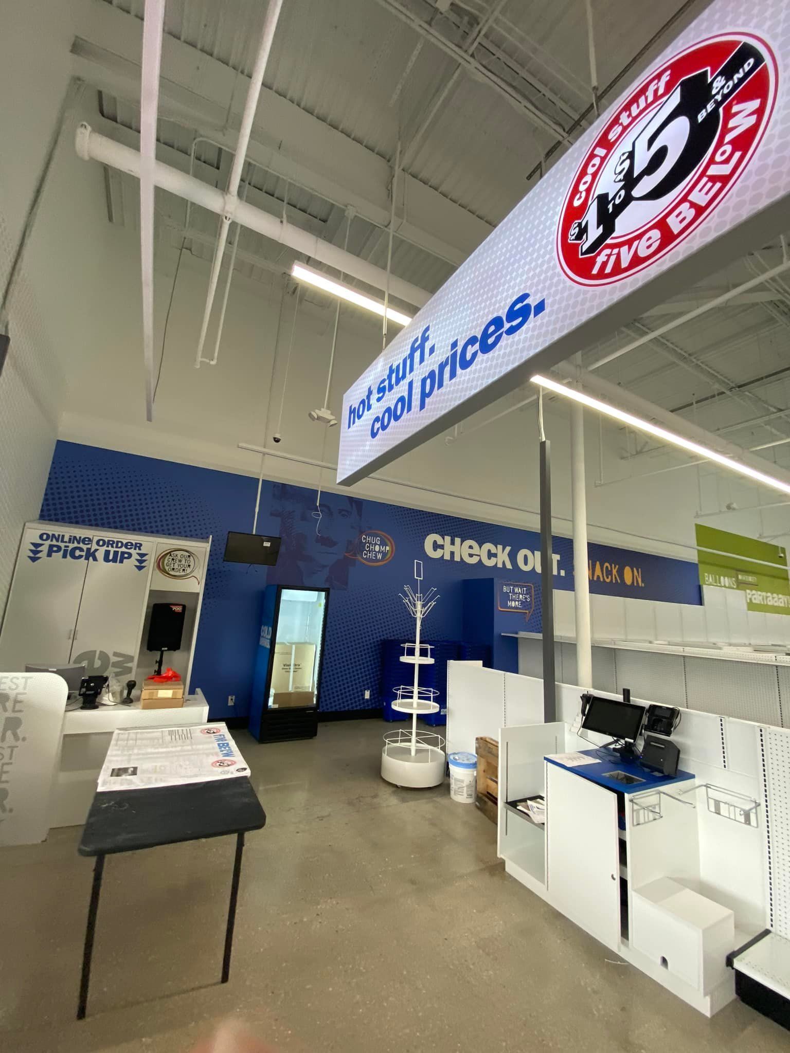 The inside of a store with a sign hanging from the ceiling.