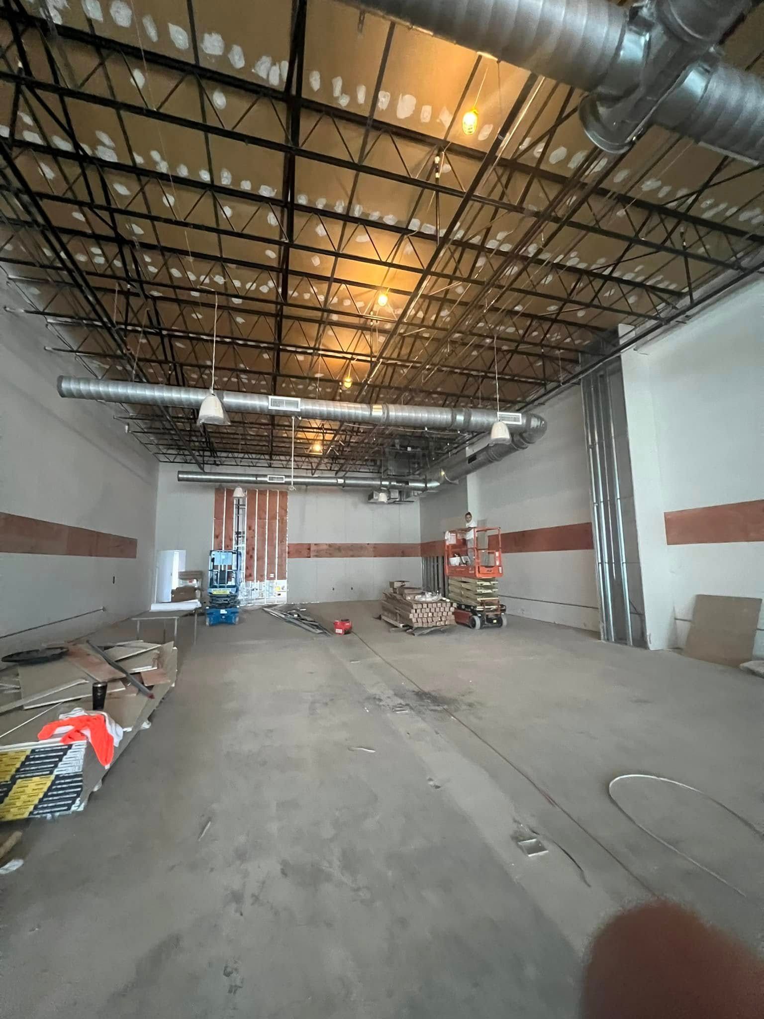 A large empty warehouse with a ceiling that is being remodeled.