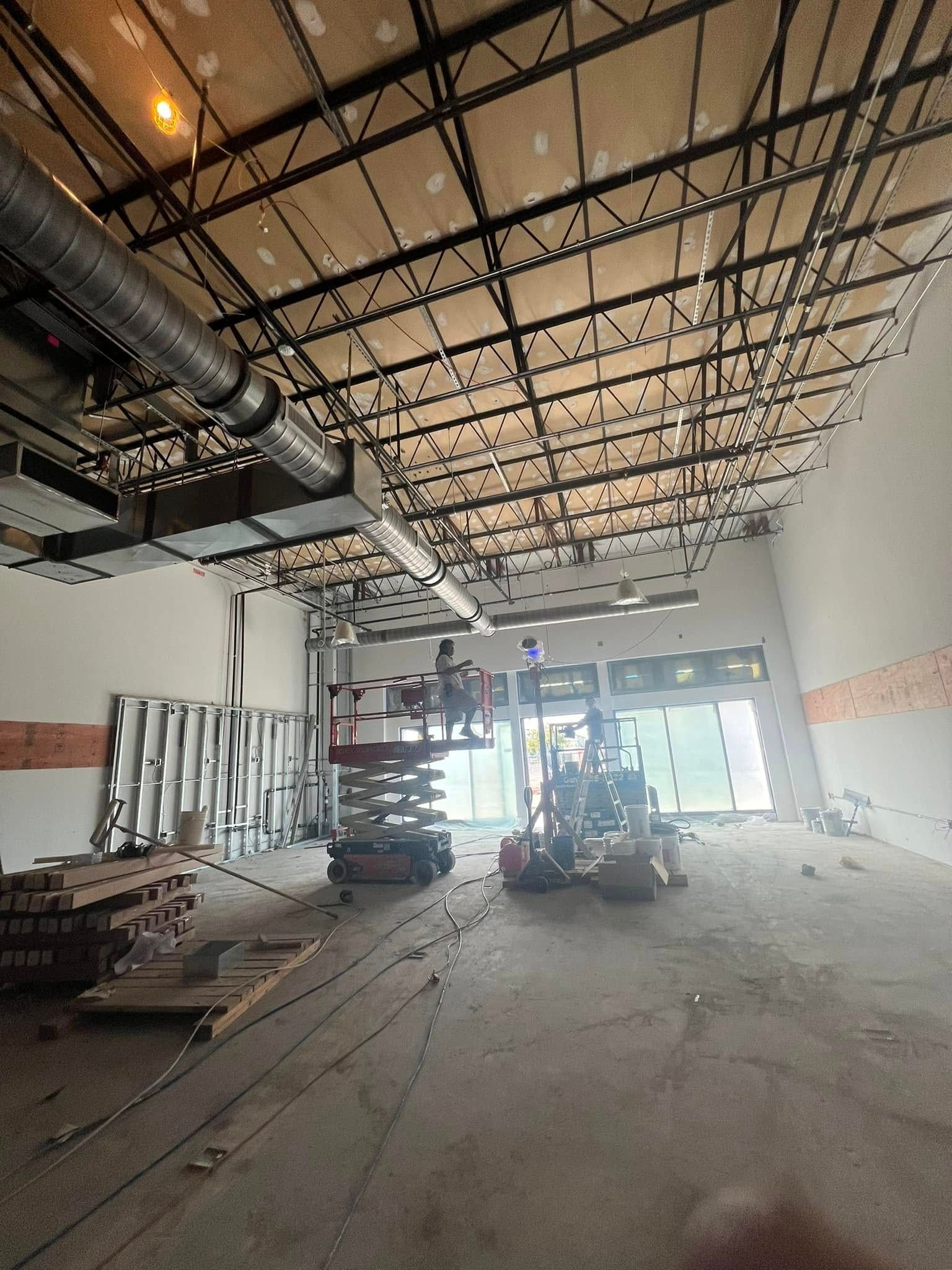 A large room with a ceiling that is being built.