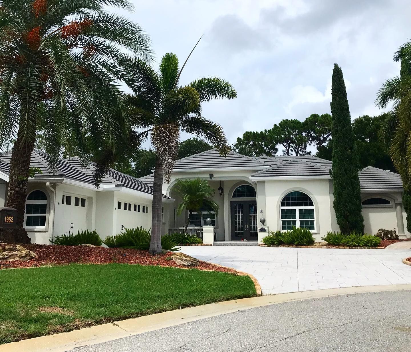 A white house with a palm tree in front of it
