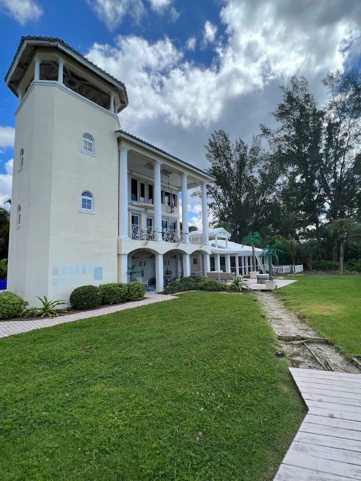 A large white building with a large lawn in front of it.