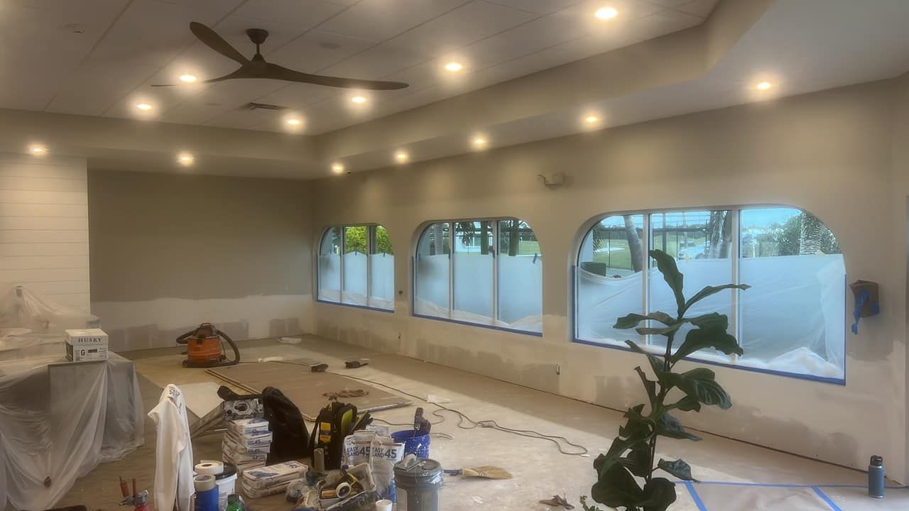 A room with a lot of windows and a ceiling fan.