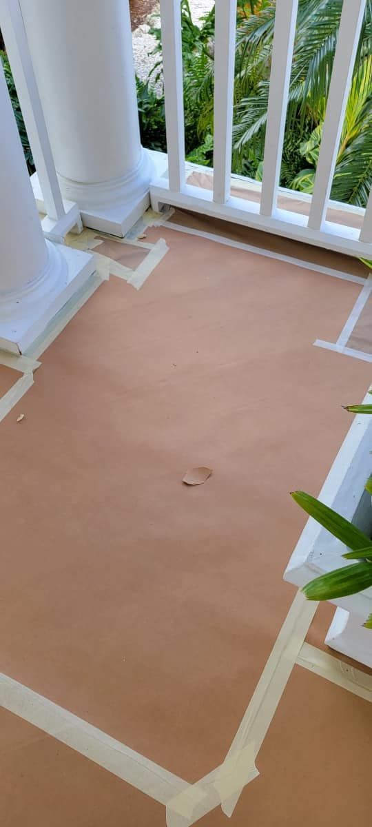 A porch with a white railing is being painted.