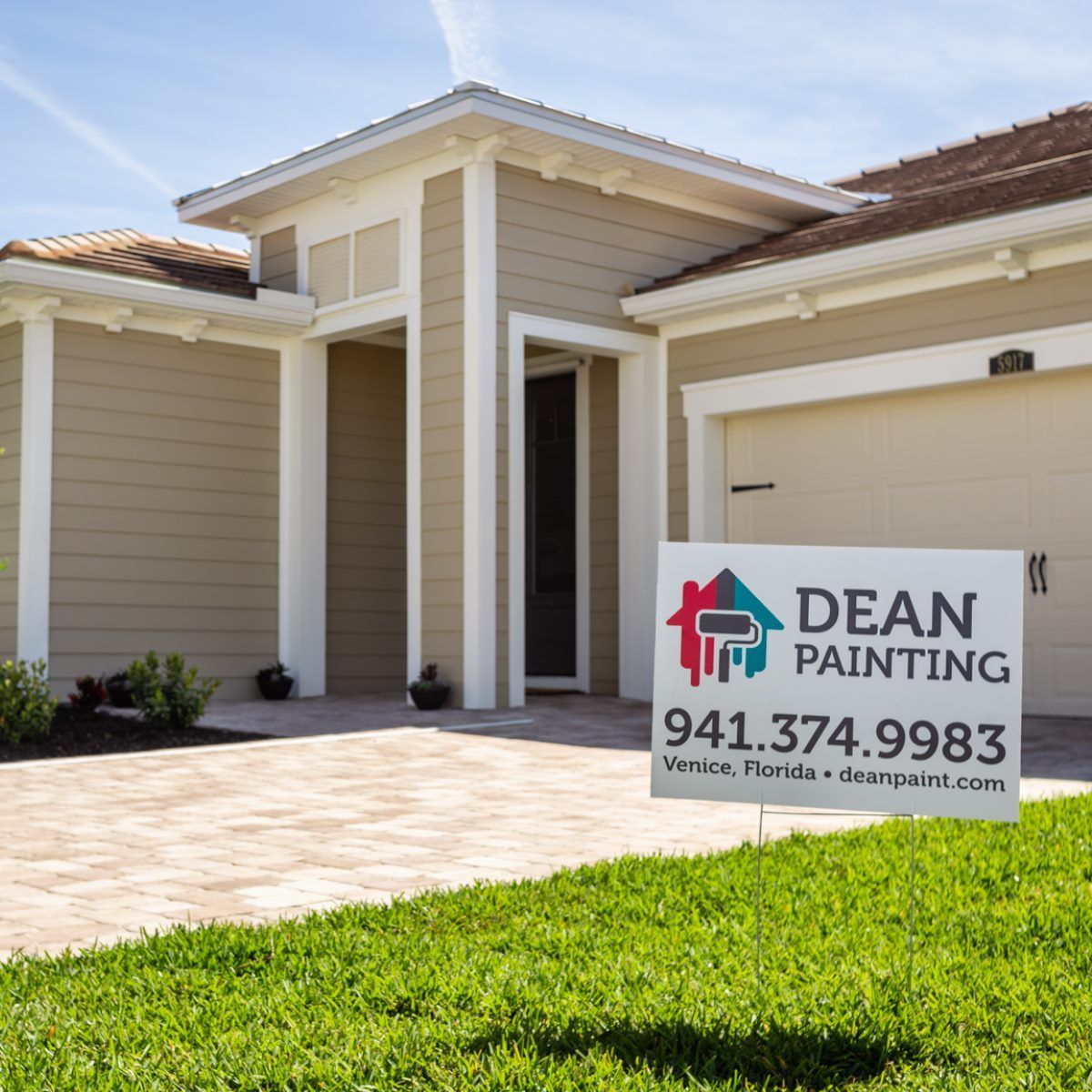 A house with a dean painting sign in front of it
