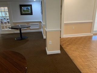 A room with a table and a picture on the wall.