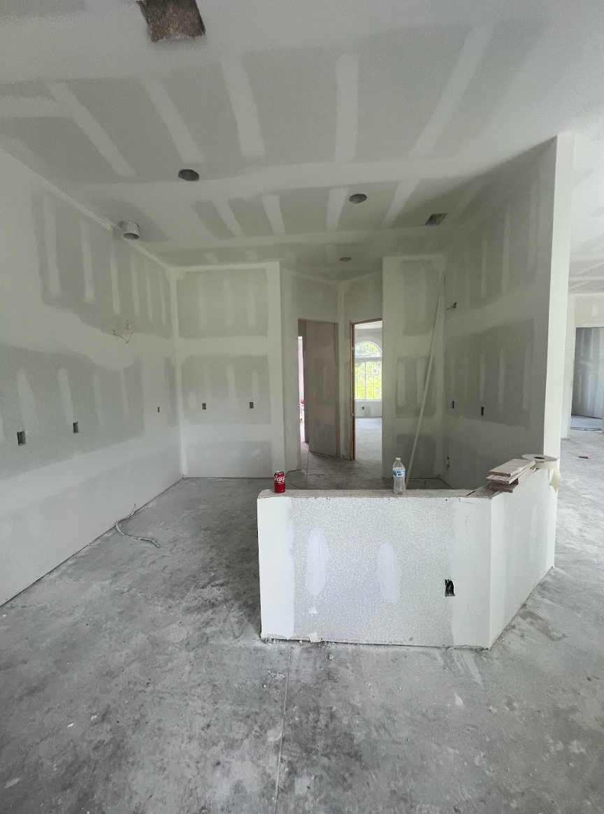 An empty room with drywall on the walls and a door