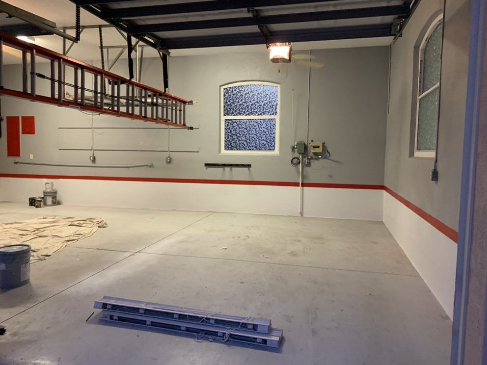 An empty garage with a ladder hanging from the ceiling