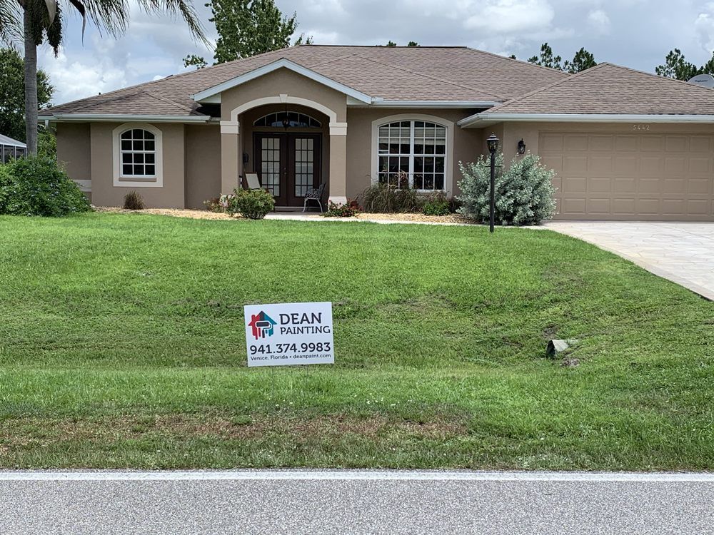 A car is parked in front of a large house.