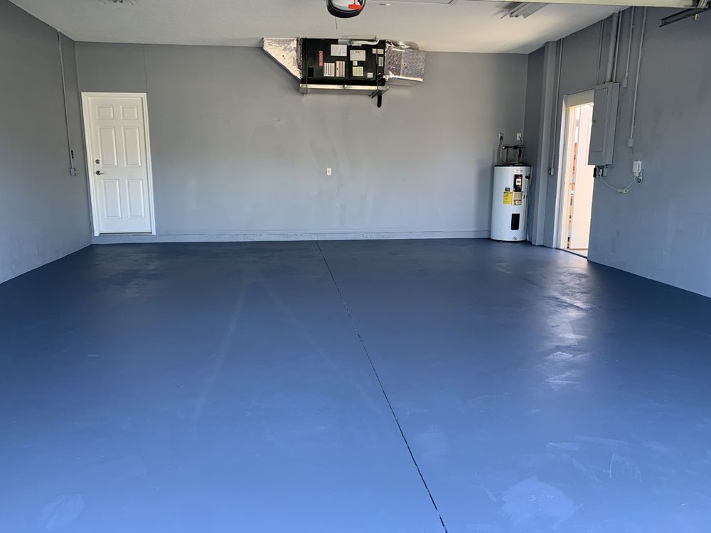 A person wearing a green shirt that says ' painting company ' on it