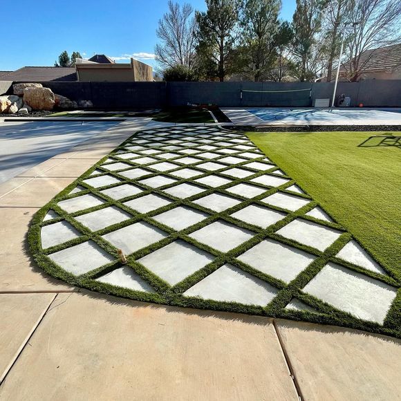 A patio with a walkway and a swimming pool in the background.