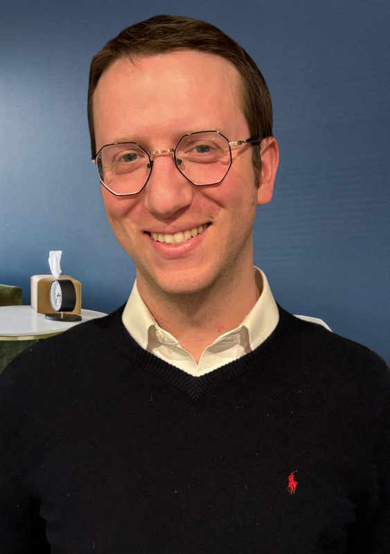A man wearing glasses and a polo shirt is smiling for the camera.