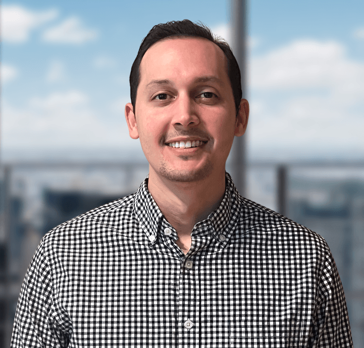 A man in a plaid shirt is smiling for the camera.