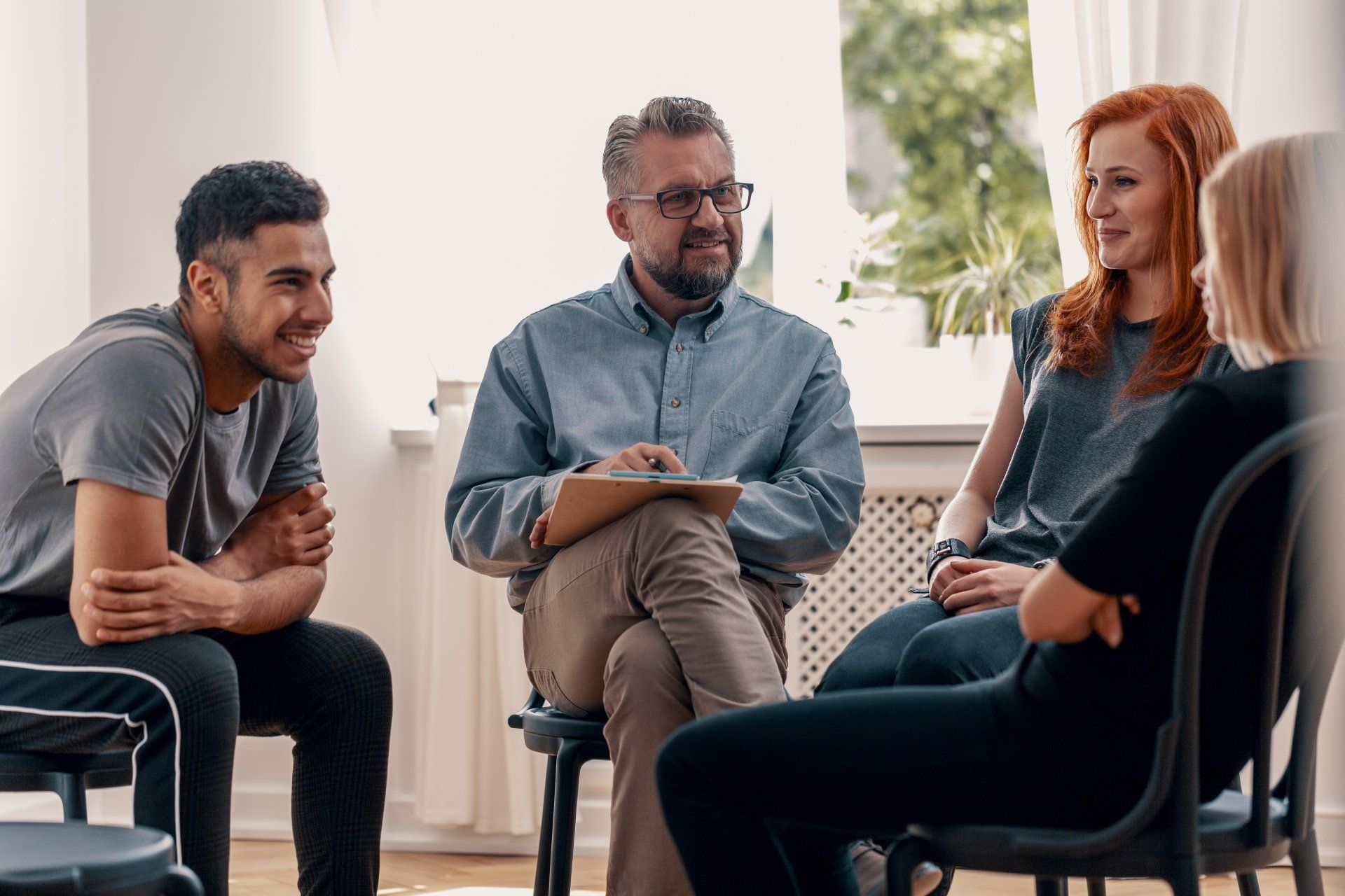 A group of people are sitting in a circle talking to each other.