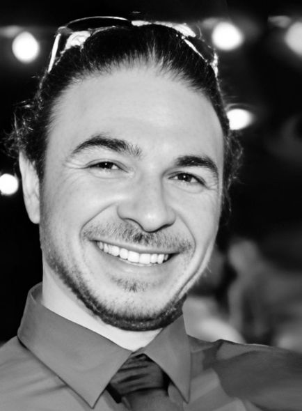 A black and white photo of a smiling man wearing sunglasses