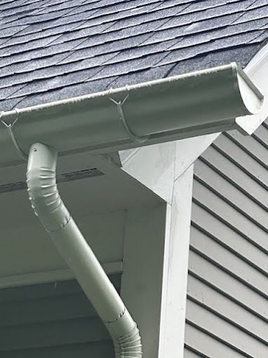 A close up of a gutter on the side of a house.