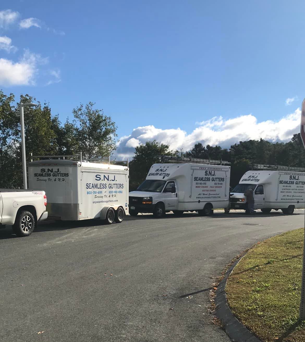 Several trucks are parked on the side of the road including one that says g.n. security