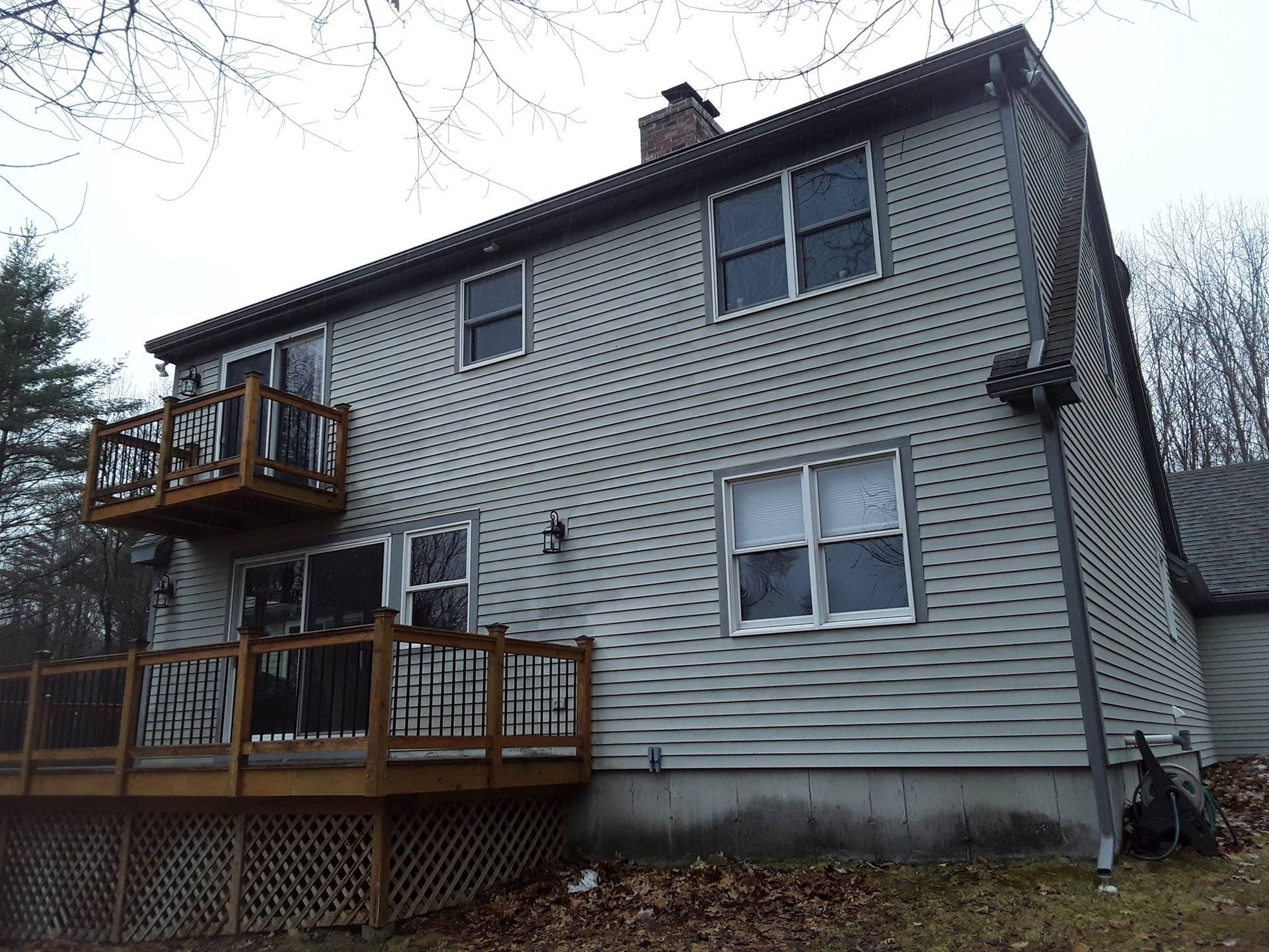 The back of a house with a deck and a balcony