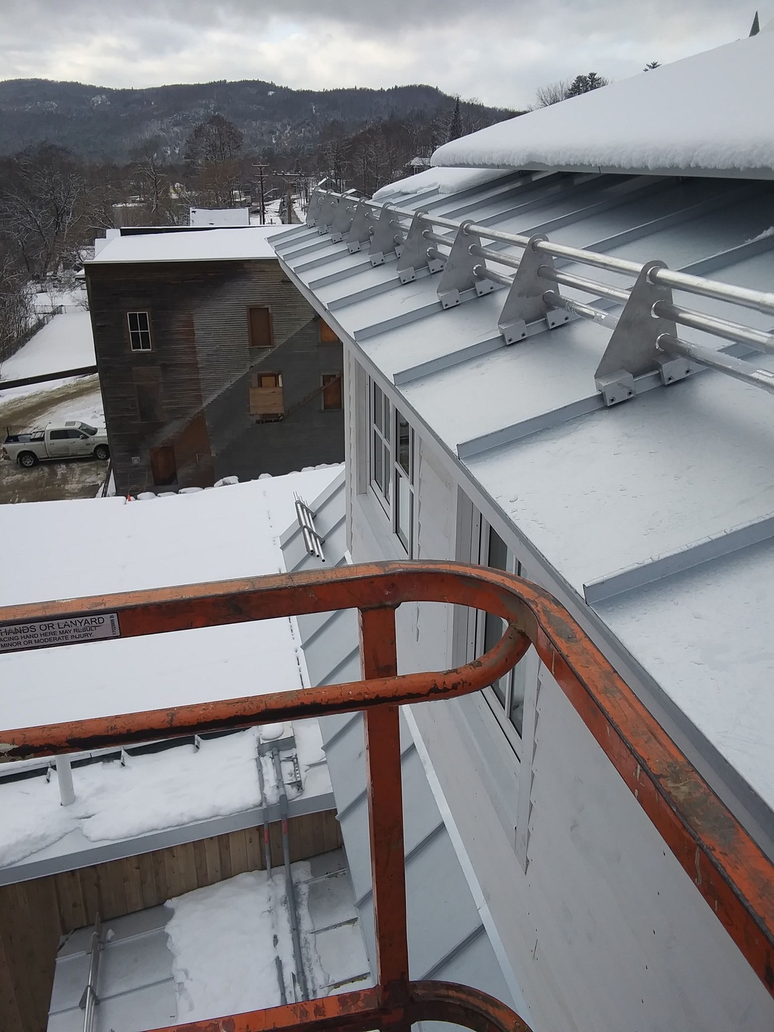 A view of a snowy roof from a balcony
