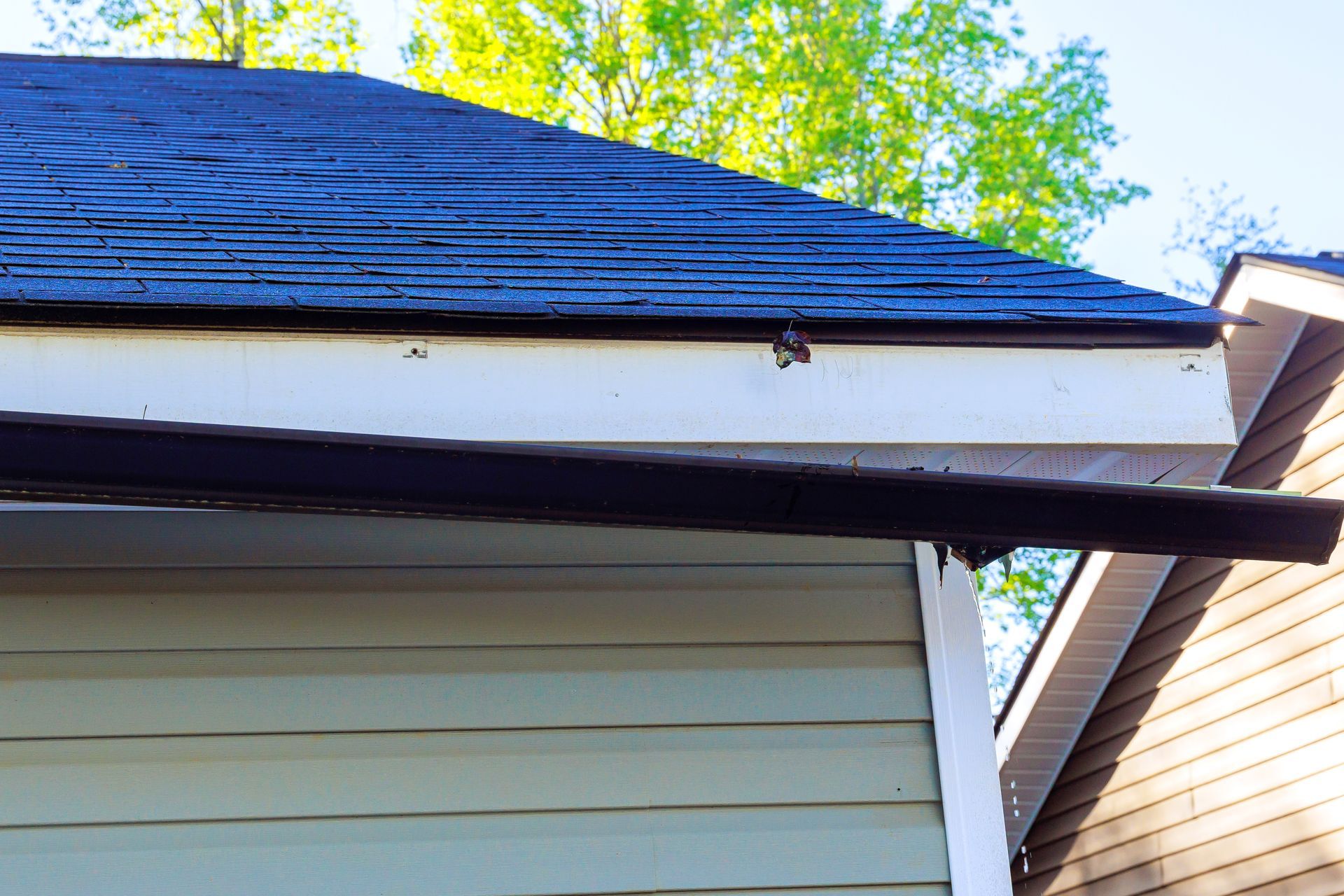 A House with a damaged rain gutter insecurely hanging from the roof.