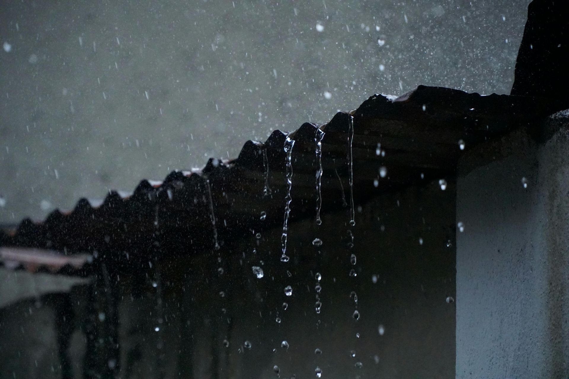 Rain poors off a Vermont roof in need of Seamless Rain Gutters