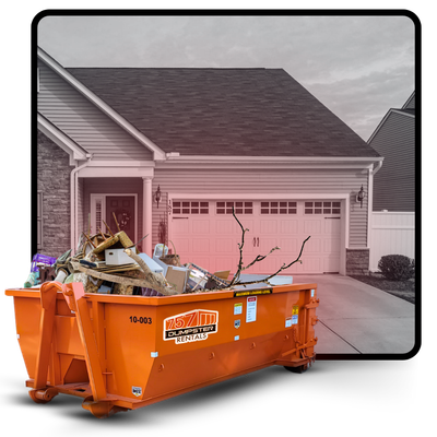 A dumpster loaded with trash in front of a house