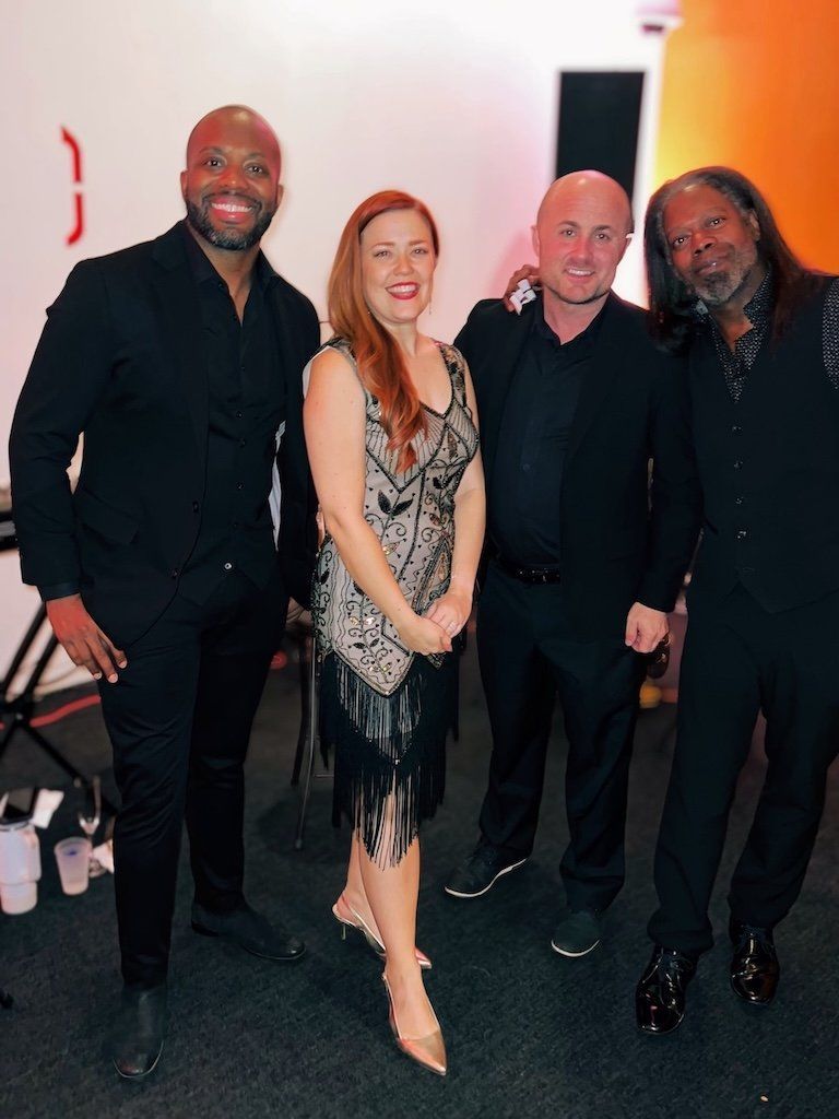 A group of men and a woman are posing for a picture