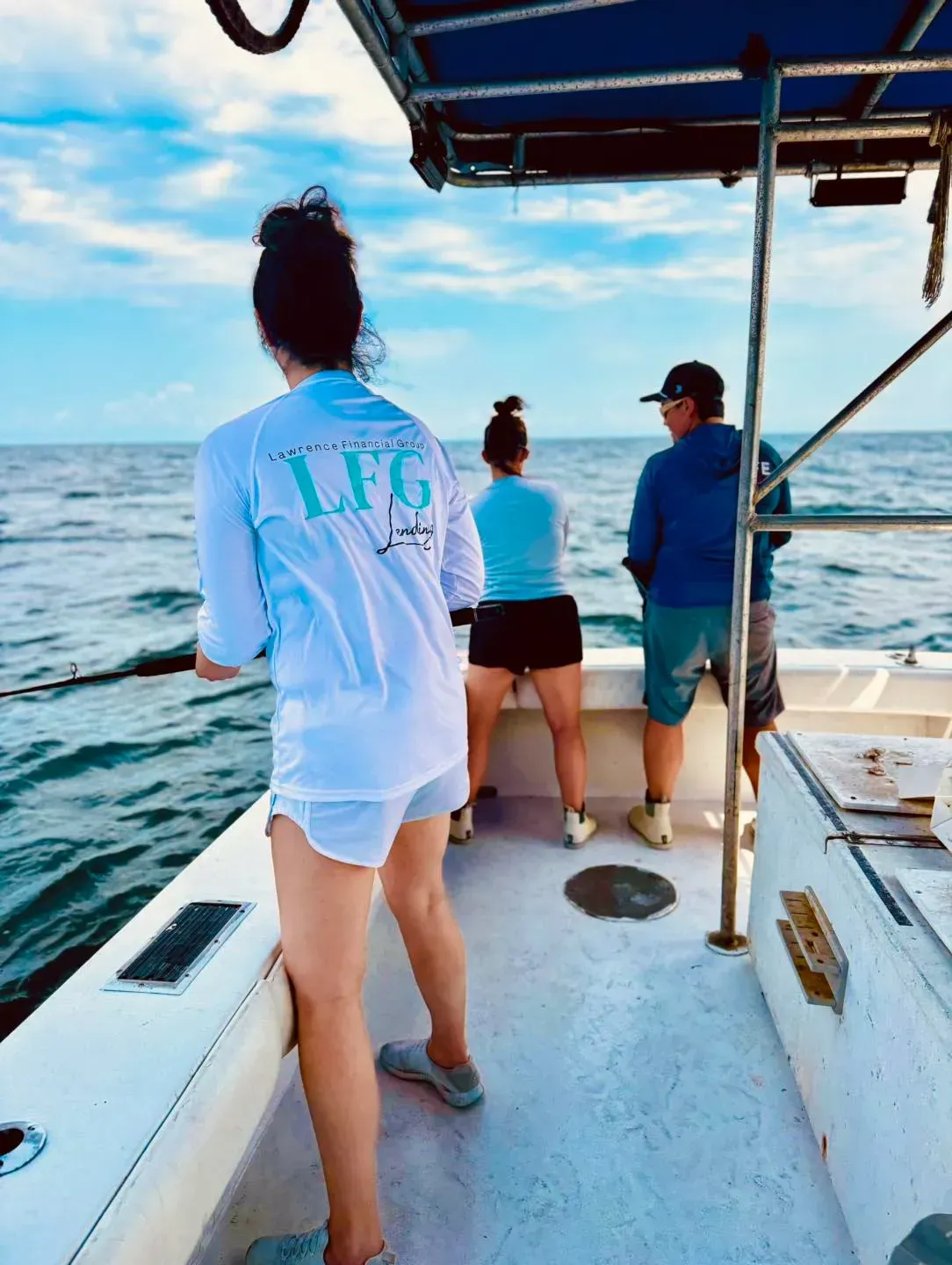 A woman wearing a shirt that says LFG is standing on a boat