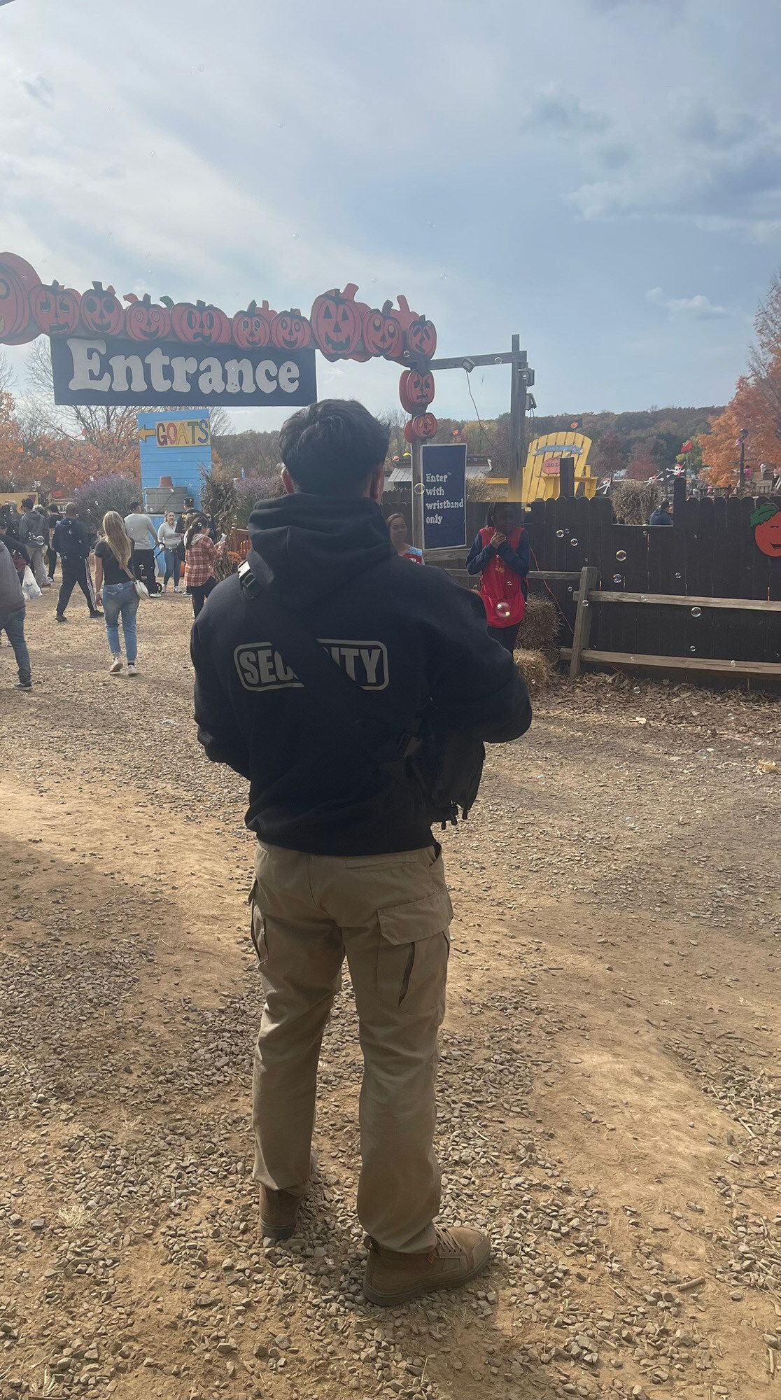 Security guard at an event entrance, wearing black hoodie that says 