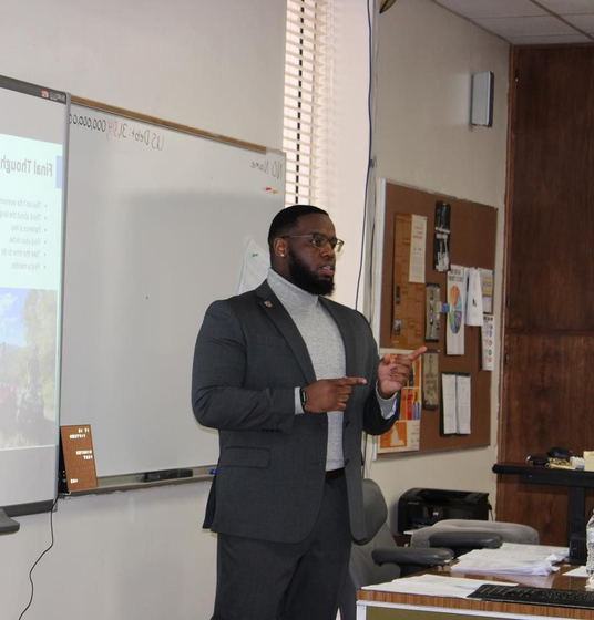 A white truck is parked in a parking lot next to a building.