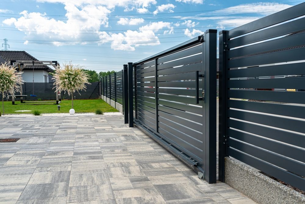 Dark Gray Sliding Gate on a Paved Driveway — Busy Bees Blasting in Trinity Beach, QLD