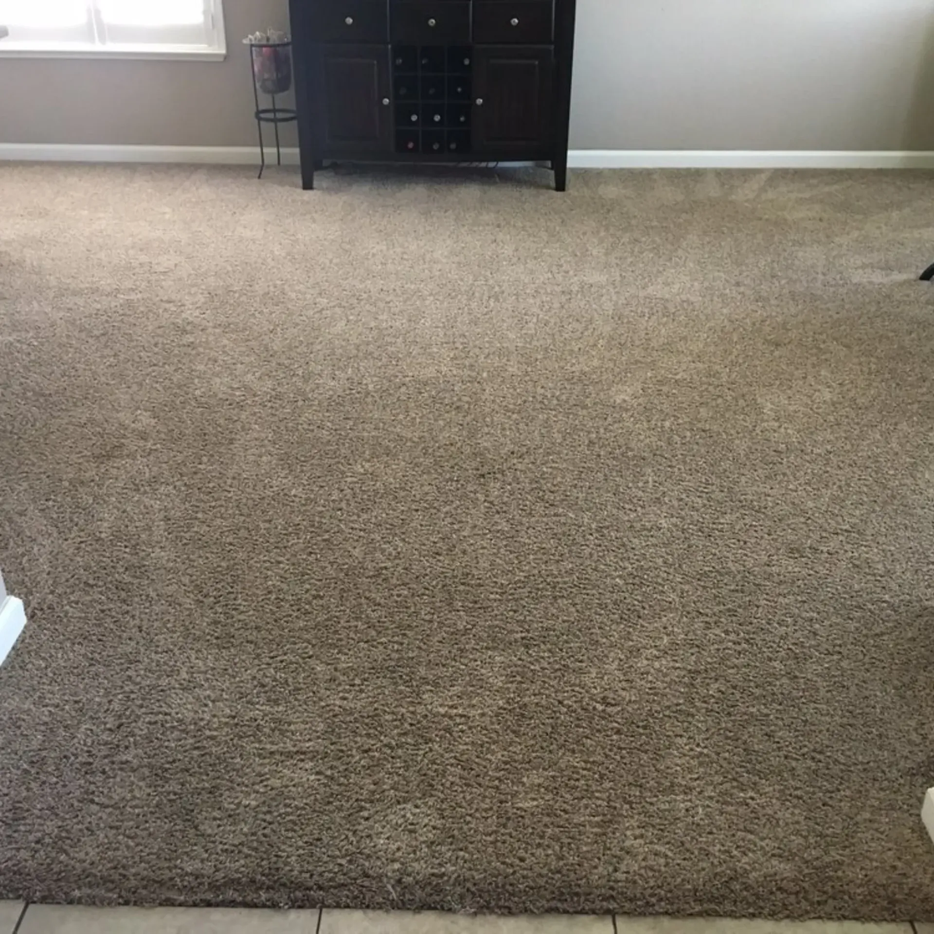 Clean Dry Carpet Care - A large carpeted floor in a living room with a dresser in the background.