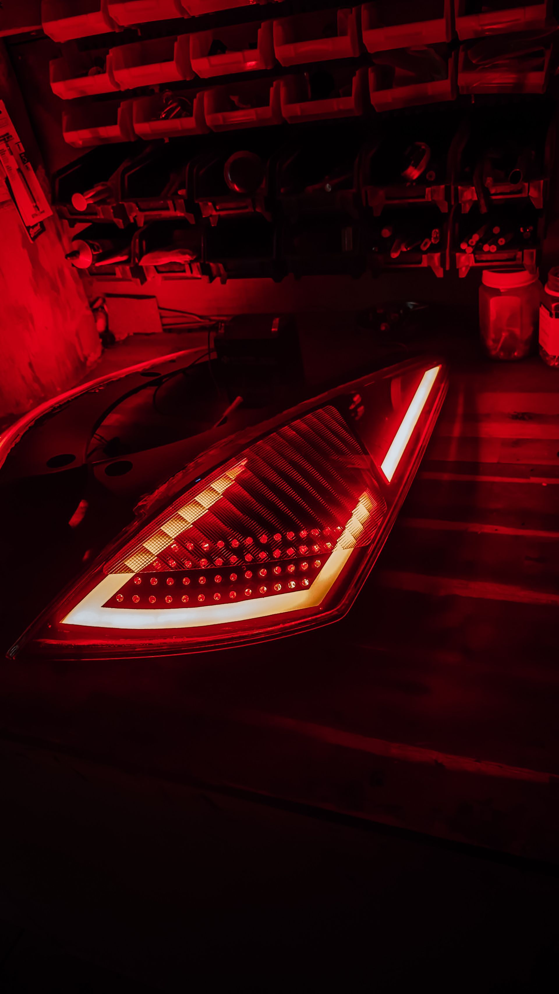 Red taillight of a car illuminated in a dim garage.