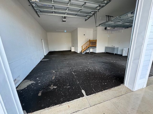 An empty garage with a staircase leading up to it