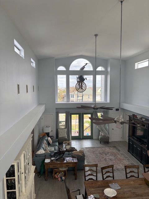 A living room with a lot of windows and a ceiling fan