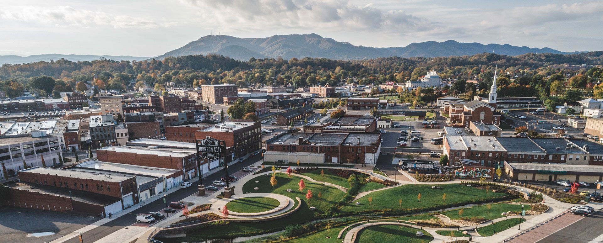 An aerial view of a small town with mountains in the background.