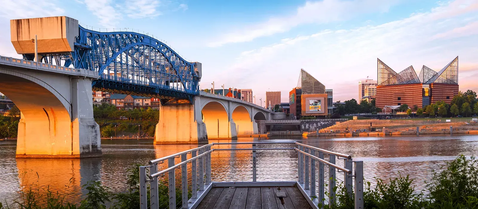 A bridge over a body of water with a dock in the foreground.