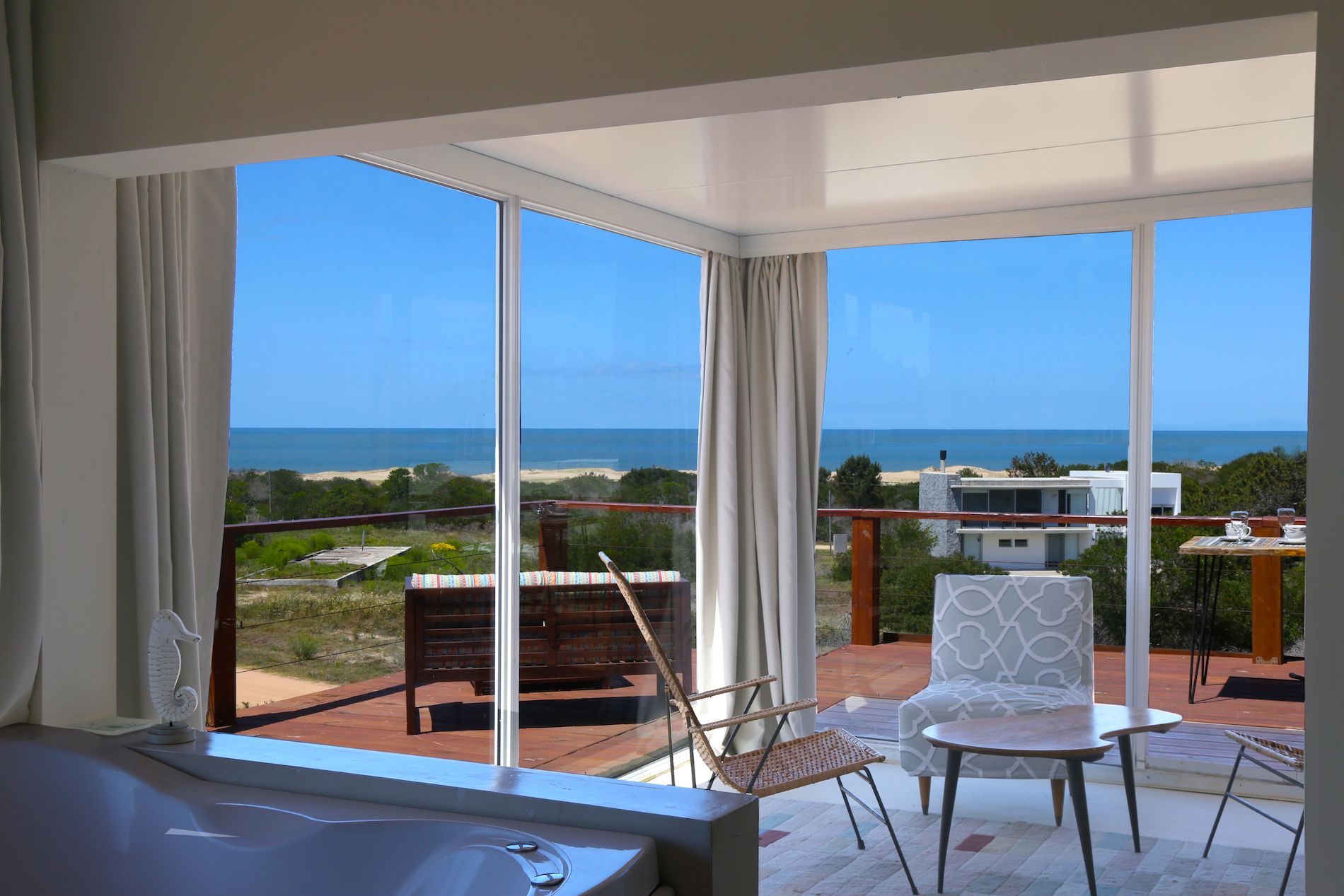 Una sala de estar con un gran ventanal con vista al mar.