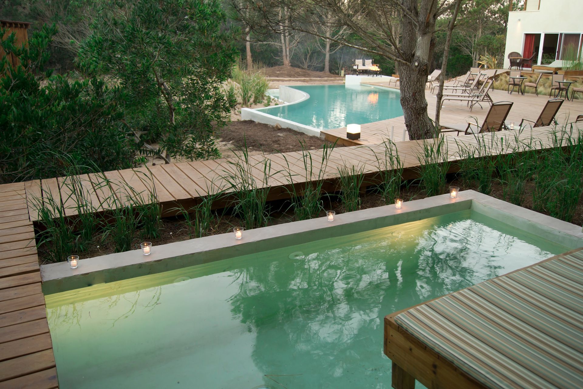 Una gran piscina rodeada de sillas y árboles.