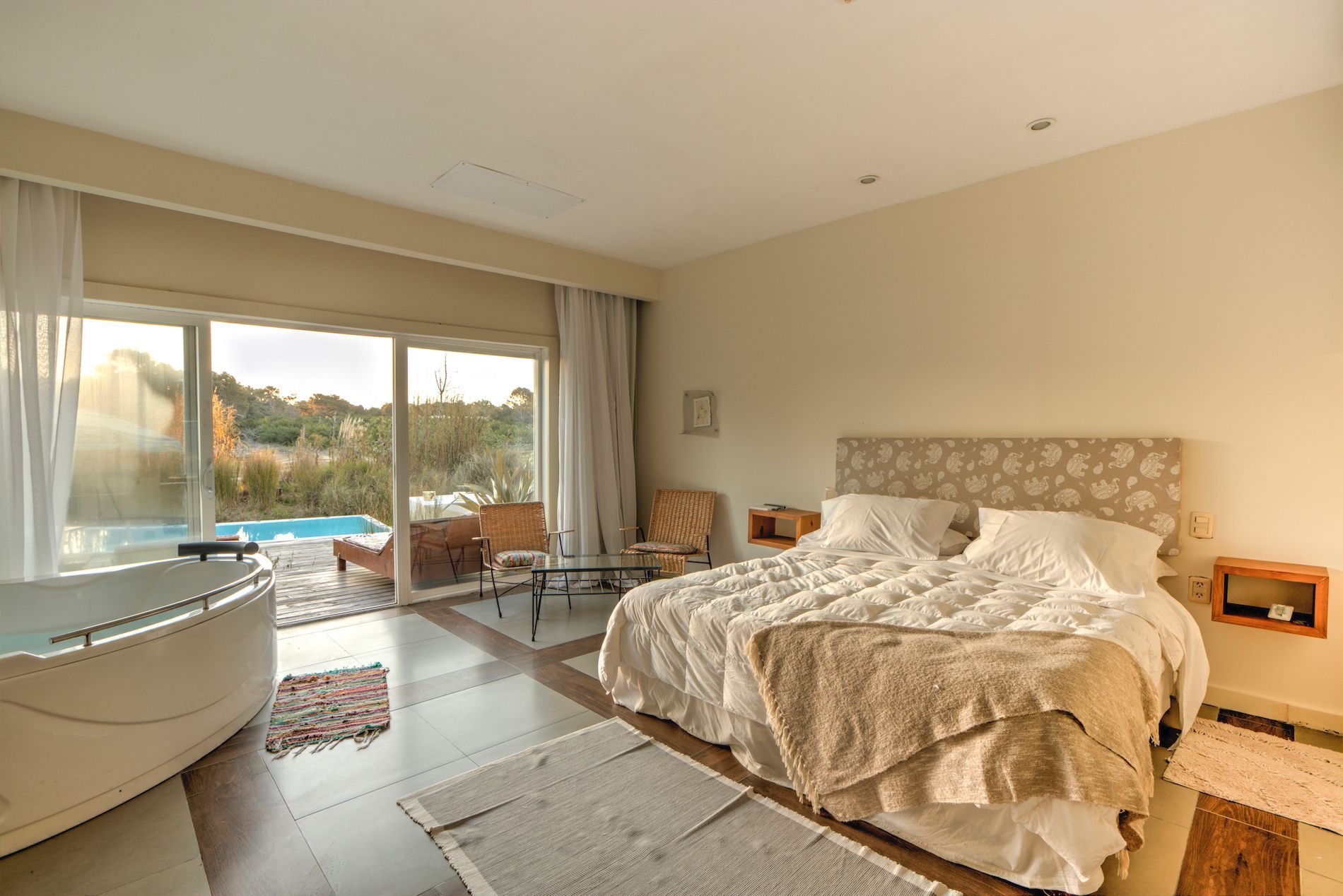 Un dormitorio con una cama grande y una bañera de hidromasaje.